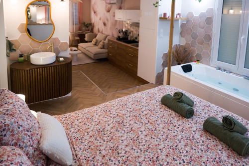 un ampio bagno con vasca e due asciugamani sul letto di La Parenthèse Fleurie - Suite avec balnéo au coeur de Bergerac a Bergerac