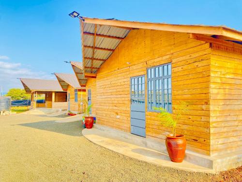 a wooden building with two plants in front of it at Twende Home lodge in Arusha