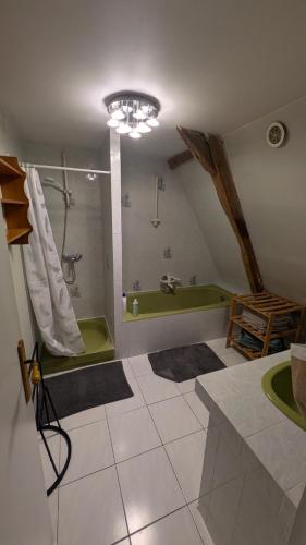 a bathroom with a green tub and a sink at House - comfortable - spacious - 15' from Lille in Leers