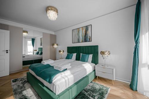 a bedroom with a large bed with a green headboard at FLH - Panoramic Garden Luxury Apt in Cristian