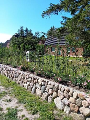 a stone retaining wall in front of a house at Nebel-s-Hues-Eg in Nebel