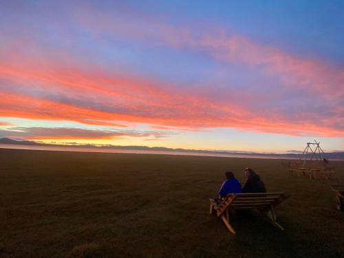 two people sitting on a bench watching the sunset at Yurt Camp Ali-Nur, Lake Song-Kul , Kyrgyzstan, Юрточный лагерь Али Нур, на берегу озера Сон Кол in Naryn
