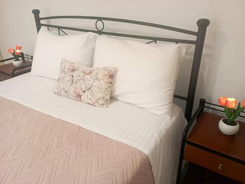 a bed with white sheets and two pillows on it at Sweet Home Lefkas in Lefkada Town