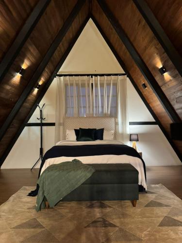 una camera da letto con un letto grande in una mansarda di Cabana Molina - Ofurô, Lareira e Vista Única a Pirenópolis