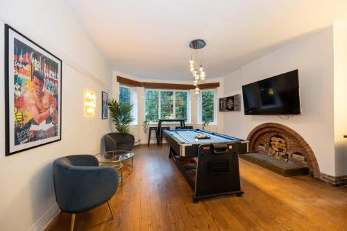 a living room with a pool table and a fireplace at The GreyStoke Mansion With Private Grounds in Hale