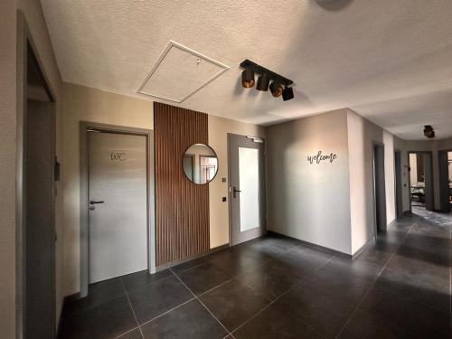 a room with a hallway with a door and a mirror at STAYtion Ferienhaus Balingen in Balingen