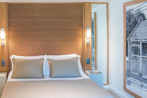 a bedroom with a large bed with a wooden headboard at Canonnier Beachcomber Golf Resort & Spa in Pointe aux Cannoniers