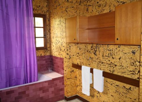 a bathroom with a purple shower curtain and towels at Tour des hirondelles in Écuras