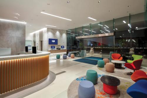 a lobby with colorful chairs and tables in a building at Holiday Inn Express Singapore Orchard Road by IHG in Singapore
