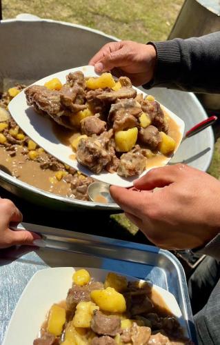 two people holding plates of food on a table at Yurt Camp Ali-Nur, Lake Song-Kul , Kyrgyzstan, Юрточный лагерь Али Нур, на берегу озера Сон Кол in Naryn