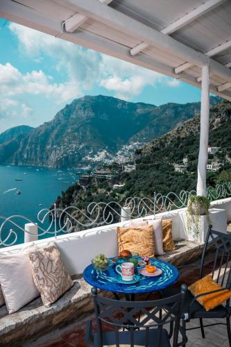 a table on a balcony with a view of the ocean at Villa Santa Chiara Positano Suites in Positano