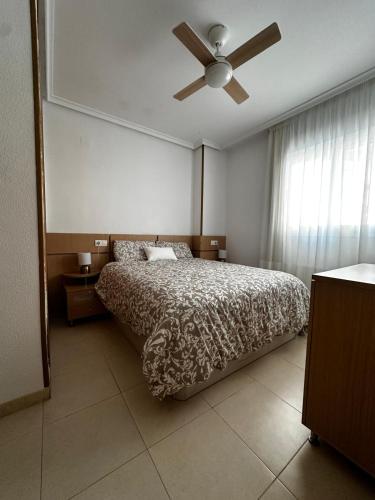 a bedroom with a bed and a ceiling fan at Vacaciones en primera línea in El Borseral