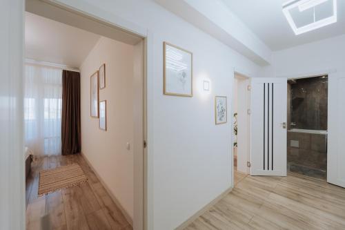 a hallway with white walls and wooden floors at Modern Stay Rîșcani, AC, WiFi, Washer in Chişinău