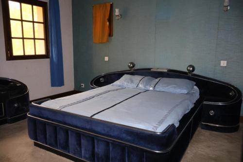 a bed in a room with a blue bed frame at Tour des hirondelles in Écuras
