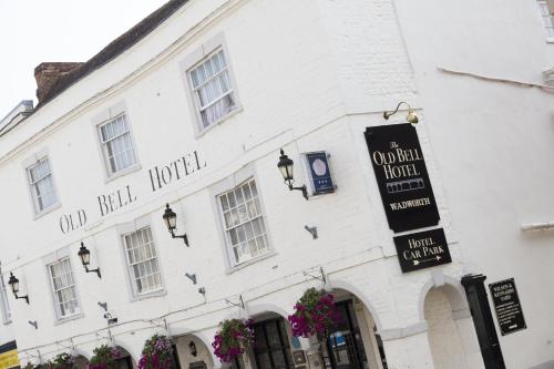 a white building with a sign for a hotel at The Old Bell - Warminster in Warminster