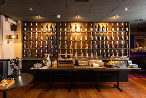 a room with a display of bottles of wine at Hampshire Hotel Petit Nord in Hoorn