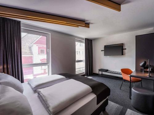 a hotel room with a bed and a large window at B&B Hotel Villingen-Schwenningen in Villingen-Schwenningen