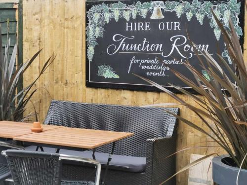 a table and chairs and a sign on a wall at The Old Bell - Warminster in Warminster