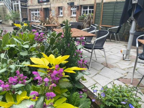a garden with flowers and a table and chairs at The Old Bell - Warminster in Warminster