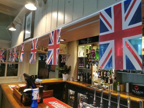 a bar with british flags on the wall at The Old Bell - Warminster in Warminster