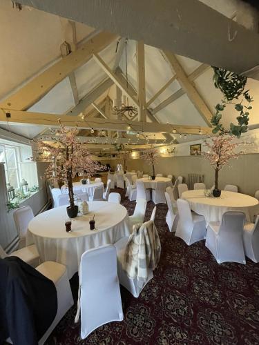 a room with white tables and white chairs at The Old Bell - Warminster in Warminster