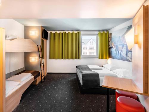 a room with two bunk beds and a table at B&B Hotel Weil am Rhein/Basel in Weil am Rhein