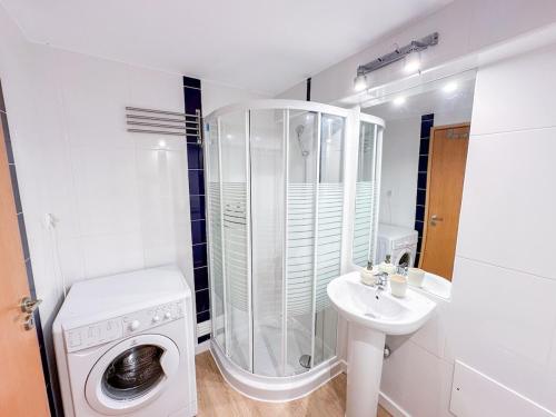 a white bathroom with a washing machine and a sink at Sunny Resort Beach House with Pools and Private beach in Tavira