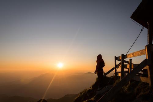 a woman standing on top of a mountain looking at the sunset at Luxury All Inclusive Resort Schwarzbrunn 4 Sterne Superior in Stans