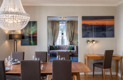 a dining room with a table and chairs and a chandelier at Enter Tromsø - Exclusive Apartments in Tromsø