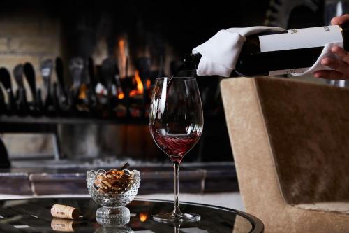 a person pouring wine into a wine glass on a table at Luxury All Inclusive Resort Schwarzbrunn 4 Sterne Superior in Stans