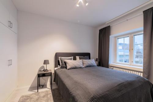 a bedroom with a large bed and a window at ULEABO Luxurious And Spacious 55m2 Apartment With Sauna! in Oulu