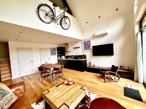 a living room with a bike hanging from the ceiling at Loft arty à 800 mètres de la plage avec jacuzzi in Veulettes-sur-Mer