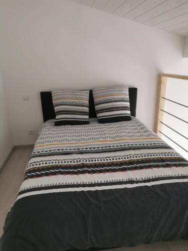 un lit dans une chambre avec deux oreillers dessus dans l'établissement Studio La Gâche, à Saint-Christoly-de-Blaye
