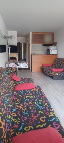 a room with two beds and a colorful blanket at studio gourette pyrenees 4 pers pied des pistes in Gourette