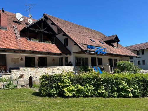 a hotel with a red roof and some bushes at Hotel Zum Forst in Kranzberg