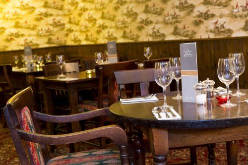 a table in a restaurant with wine glasses on it at The Old Bell - Warminster in Warminster