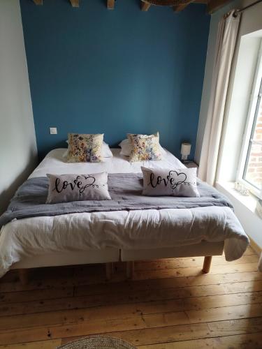 a bed in a room with a blue wall at Le Gite du Moulin de la Pisciculture de Monchel sur Canche in Conchy-sur-Canche