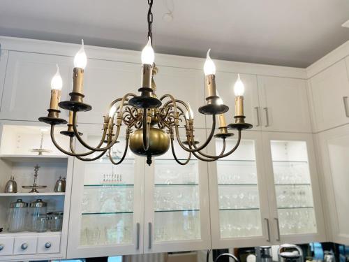 a chandelier in a kitchen with white cabinets at Villa Stolle in Schneverdingen