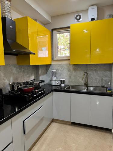 - une cuisine avec des placards jaunes et un évier dans l'établissement Hotel Fortune Home E-46 Noida Sector 72, à Noida