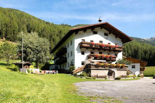 a large white building with flowers on the balcony at Bed and Breakfast Ederhof in San Giacomo