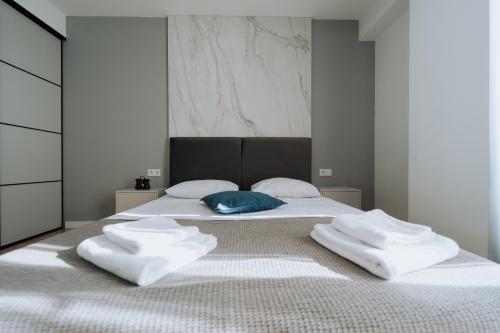 a bedroom with a bed with two towels on it at Modern 1BR Great Area Near McDonalds Riscani in Chişinău