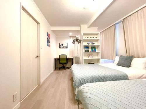 een slaapkamer met 2 bedden en een bureau met een stoel bij Modern Tokyo Suites in Tokyo