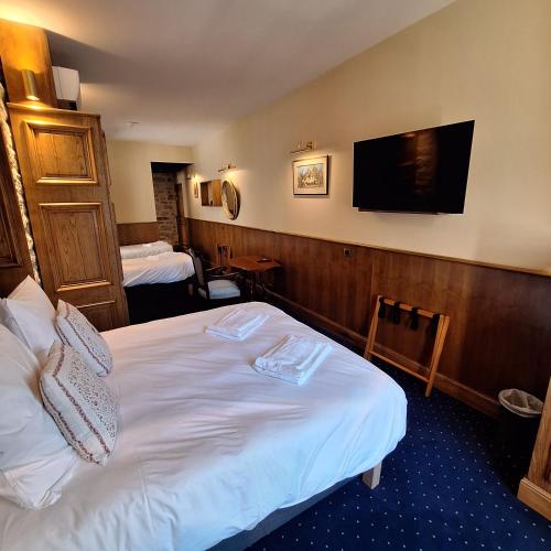 a hotel room with a bed and a flat screen tv at Hôtel-Restaurant Le Manoir De Montesquiou in La Malène