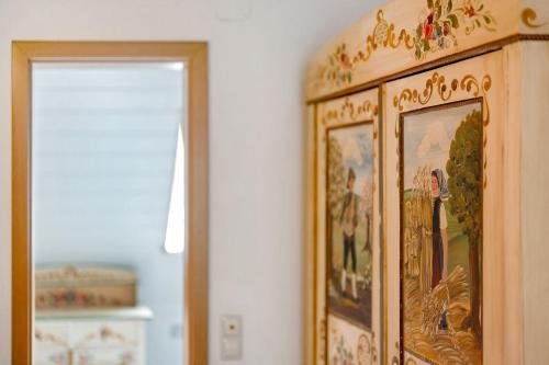 a wooden cabinet with a painting on the wall at Ruhbauernhof in Kirchzarten