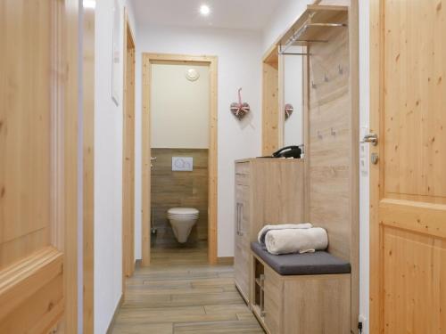 a bathroom with a toilet and a wooden door at Ferienwohnung Eulennest in Wolfach