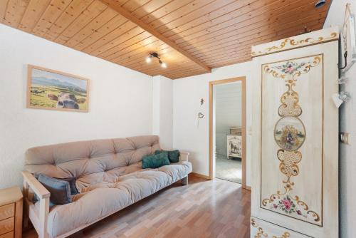 a living room with a couch and a wooden ceiling at Ruhbauernhof in Kirchzarten