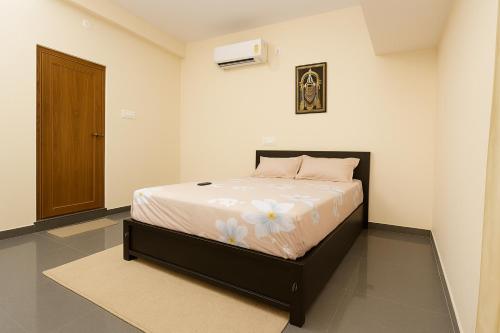a bedroom with a bed with flowers on it at Suprabhatam Homestay - New luxurious 2BHK AC apartment with Kitchen and car parking in Tirupati near railway station and bus stand in Tirupati