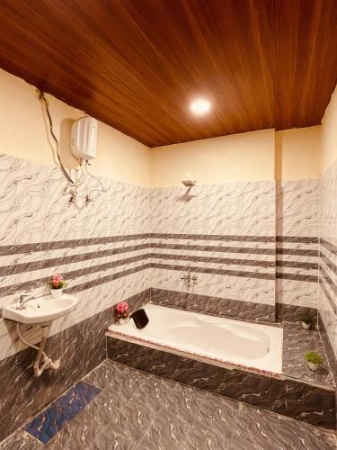 une salle de bain avec un lavabo et une baignoire dans l'établissement Hotel BR Palace, à Hyderabad