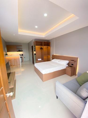 a large bedroom with a bed and a couch at Barsons Transient Unit in Pagbilao