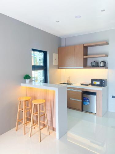 a kitchen with two bar stools and a counter at Barsons Transient Unit in Pagbilao